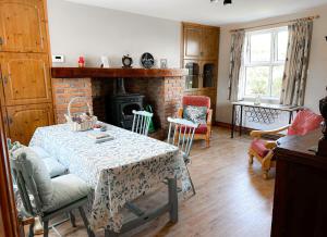 a living room with a table and a fireplace at Lisheenbawn Farmhouse Farranfore in Farranfore