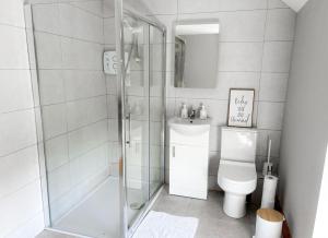 a white bathroom with a shower and a toilet at Lisheenbawn Farmhouse Farranfore in Farranfore