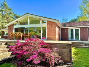 a home with a porch with pink flowers at Luxury Five Bed Home - Large Garden with BBQ - New Forest and Beach Links in Saint Leonards