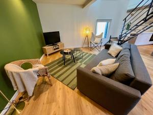 a living room with a couch and a television at La maison de Paulette in Onzain