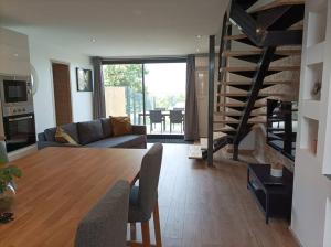 a living room with a table and a living room with a staircase at Appartement Caraman in Caraman