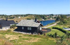 a house sitting on top of a hill next to a river at Stunning Home In Bvgen With House Sea View in Bøvågen