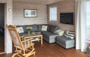 a living room with a couch and a tv at Stunning Home In Bvgen With House Sea View in Bøvågen