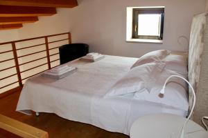 un letto bianco in una stanza con finestra di Antica Masseria Timparuci a Modica