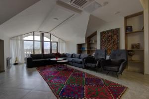a living room with a couch and chairs and a rug at Aisha Hotel in Bishkek