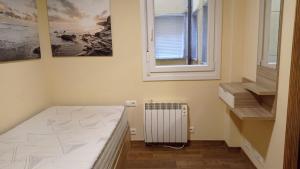 a room with a bed and a window and a radiator at Fondás in Foz