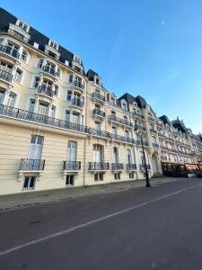 un gran edificio blanco con balcones en una calle en Le Coquillage Bleu, charmant 2 pièces, proche plages et commerces, en Cabourg