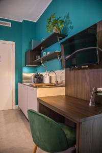 a kitchen with blue walls and a green chair at Casa Consani in Ventimiglia