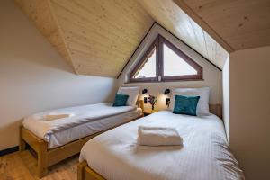two beds in a small room with a window at Domek Bajkowy Widok in Maniowy