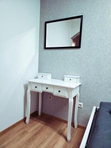 a white dressing table with a mirror on a wall at B&R apartment türkischen Konsulats in Nürnberg