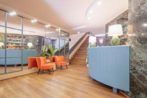 um átrio de escritório com cadeiras laranja e uma escada em Hotel Acta Azul Barcelona em Barcelona