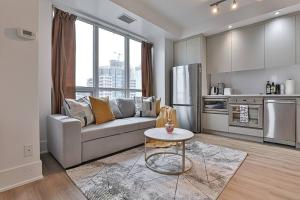 a living room with a couch and a kitchen at New 3 BR with Free parking Downtown Toronto in Toronto