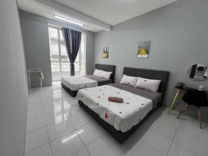 a bedroom with two beds and a window at Naufa Muslim's Homestay at Emerald Avenue Brinchang in Brinchang