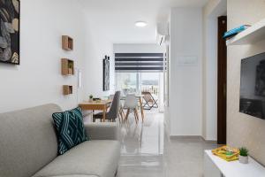 a living room with a couch and a table at Blue Hues Apartments in Il-Ħamra
