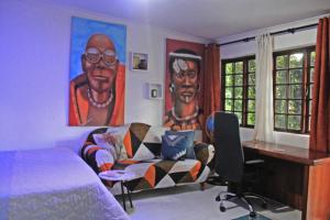 een slaapkamer met een bed, een bureau en een bank bij Trendy Johannesburg Cottages in Johannesburg