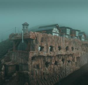 eine Steinmauer mit Häusern darüber in der Unterkunft Amazena in Çamlıhemşin