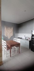 a dining room with a wooden table and white chairs at D'tegal Guest House-Tropical Garden in Canggu in Tumbak Bayuh
