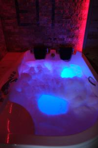 - un bain à remous avec des lumières bleues et vertes dans la chambre dans l'établissement Özden Bungalow, à Çamlıhemşin