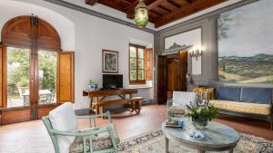 sala de estar con mesa, sillas y sofá en VILLA TREGGIAIA 12&2, Emma Villas, en San Casciano in Val di Pesa