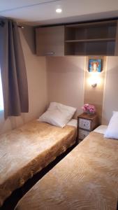 2 camas en una habitación con en Maison mobilhome sans vis à vis au calme et en hauteur, en Lège-Cap-Ferret