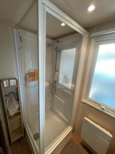 a walk in shower in a bathroom with a window at Maison mobilhome sans vis à vis au calme et en hauteur in Lège-Cap-Ferret