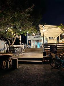ein Restaurant mit Tischen und Stühlen in der Nacht in der Unterkunft オーシャンビューゲストハウスEat&Stay ROMEY in Shizuoka