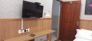 a room with a tv and a bed and a table at Waterlily Homestay in Kottayam