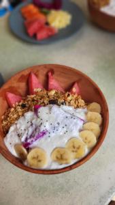a bowl of fruit and yogurt with bananas and nuts at The Barefoot Blondie Village in Gili Air +97 photos