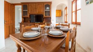 comedor con mesa de madera y sillas en Su Riu House, en Santa Caterina