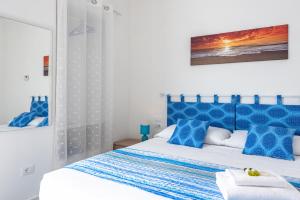 - une chambre dotée d'un lit bleu et blanc avec des oreillers bleus dans l'établissement La conchiglia dei sogni - YourPlace Abruzzo, à Rocca San Giovanni