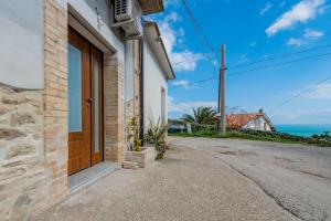 une porte menant à une maison avec l'océan en arrière-plan dans l'établissement La conchiglia dei sogni - YourPlace Abruzzo, à Rocca San Giovanni