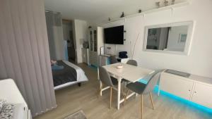 Studio 4pers aux Bains de Saillon في سايلون: غرفة معيشة مع طاولة وسرير