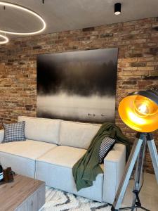 a living room with a couch in front of a tv at Apartament G13 Nautica Resort Giżycko in Giżycko