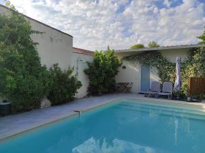 a swimming pool with two chairs next to a house at Chambre direct piscine in Talence