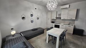 sala de estar con mesa, sofá y cocina en Residenza Novi, en Novi Ligure