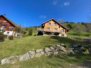 uma casa grande no topo de uma colina relvada em The dream catcher -Spa- panoramic sauna- 2 MINUTES FROM THE SLOPES em La Bresse