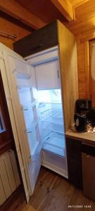 an empty refrigerator with its door open in a kitchen at The dream catcher -Spa- panoramic sauna- 2 MINUTES FROM THE SLOPES in La Bresse
