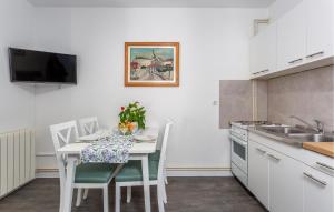 a kitchen with a white table with chairs and a sink at Stunning Apartment In Krk With Kitchen in Krk