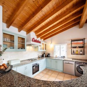 a large kitchen with white cabinets and a wooden ceiling at Seashore Escape in Aljezur