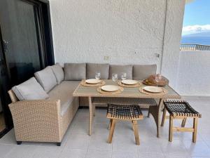 a couch and table with a table and chairs at Stunning cliffs and ocean view in Los Gigantes in Acantilado de los Gigantes