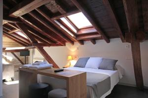 een slaapkamer met een bed en een houten plafond bij Emebed Posada in Castrojeriz