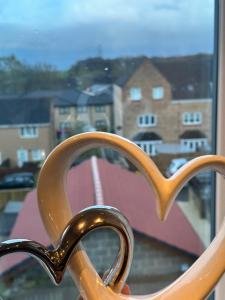 un primo piano di un paio di forbici davanti a una finestra di The Luxe By Elegant Aparts a Bradford