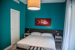 a bedroom with a bed with a green wall at RHS - Casa Consani in Ventimiglia