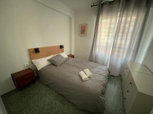 a bedroom with a bed with two towels on it at Luminoso piso cerca de la playa in Cullera