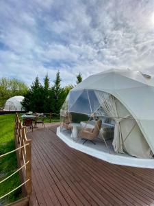 Yengica的住宿－Gabala Yengice Thermal Resort Hotel，甲板上的帐篷,配有桌椅