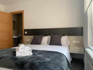 - une chambre avec un grand lit et des serviettes dans l'établissement Ramón y Cajal SUITES DE LUXE, à León