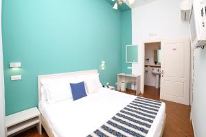 ピアノ・ディ・ソレントにあるHotel Royal Hillsの青い壁のベッドルーム1室(ベッド1台付)
