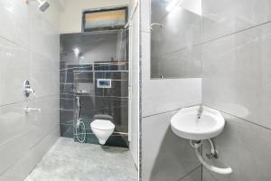 a white bathroom with a sink and a toilet at FabHotel Lake View III in Indore