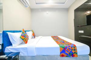 1 dormitorio con 1 cama grande y almohadas coloridas en FabHotel Lake View III en Indore