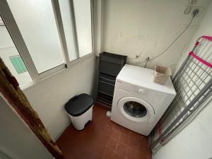 a small bathroom with a washing machine and a window at Luminoso piso cerca de la playa in Cullera